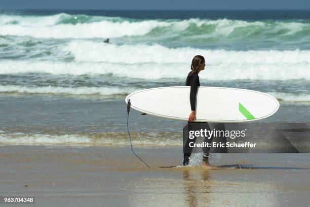 surfer in black on the beach - eric schaeffer stock pictures, royalty-free photos & images