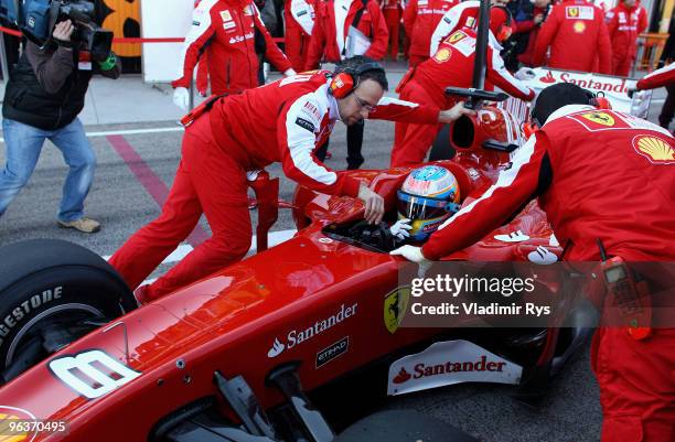 Fernando Alonso of Ferrari and Spain is pushed back in the garage by his mechanics during winter testing at the Ricardo Tormo Circuit on February 3,...