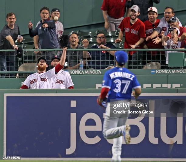 While warming up in the bullpen in the bottom of the eighth inning, Boston Red Sox closer Craig Kimbrel, far left, catches the ball that was hit...