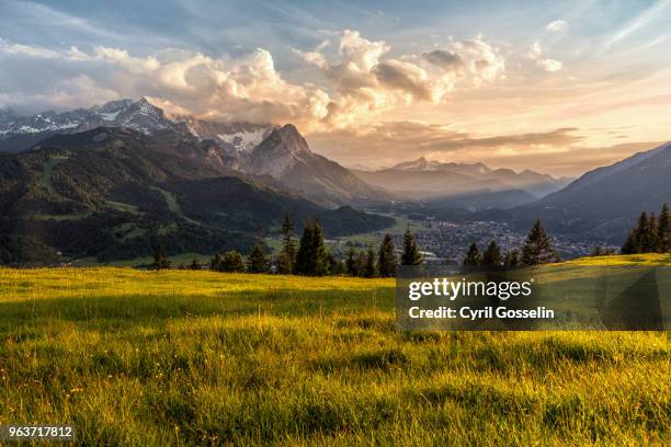 sunset at a mountain pasture over garmisch-partenkirchen - vallée photos et images de collection