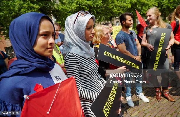 Afghan refugee and activists hold boards reading "don't send them back" as human rights group Amnesty International hand over a petition signed by...