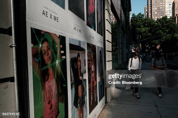 Pedestrians pass in front of an American Eagle Outfitters Inc. Advertisement displayed outside a store in New York, U.S., on Tuesday, May 29, 2018....