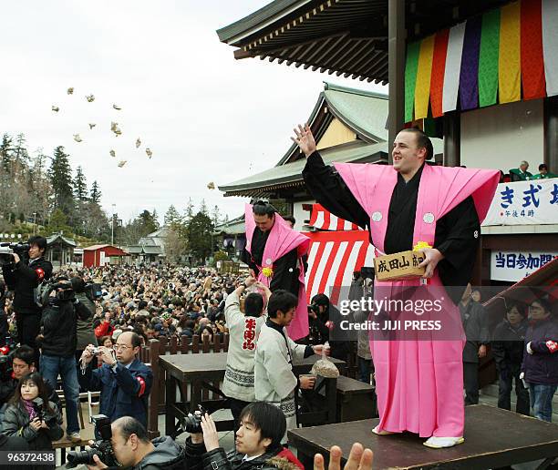 Estonian sumo wrestler Baruto throws packs of beans during a bean-throwing ceremony to drive away evils and bring good luck during the annual...