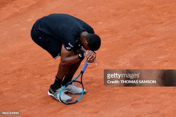 France's Gael Monfils reacts after suffering an injury during his men's singles second round match against Slovakia's Martin Klizan on day four of...