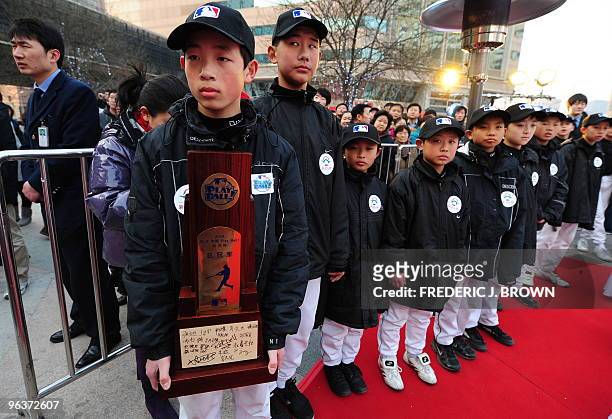 Young Chinese baseball players await the arrival of the New York Yankees 2009 World Series championship trophy displayed at a shopping mall in...