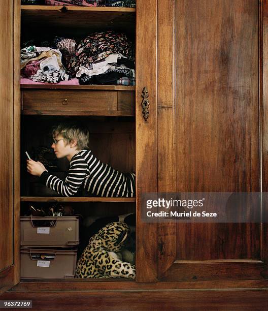 boy hidding in wardrobe - childrens closet stock-fotos und bilder