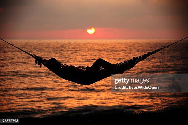 Woman relaxes in a hammock at sunset on the beach of Varkala. On January 12, 2010 in Varkala near Trivandrum, Kerala, India.