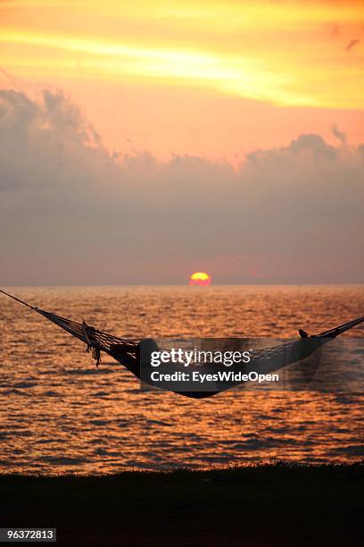 Woman relaxes in a hammock at sunset on the beach of Varkala. On January 12, 2010 in Varkala near Trivandrum, Kerala, India.