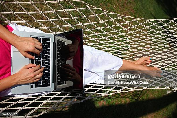 Woman lying in a hammock and working with a notebook on January 12, 2010 in Varkala near Trivandrum, Kerala, India.