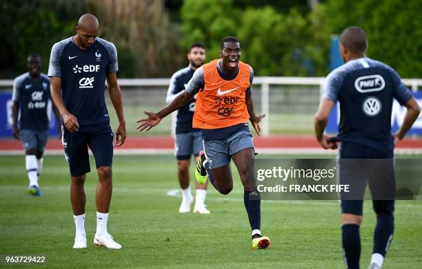 France's midfielder Paul Pogba reacts next to France's forward Kylian Mbappe and France's midfielder Steven N'zonzi at the end of a training session...