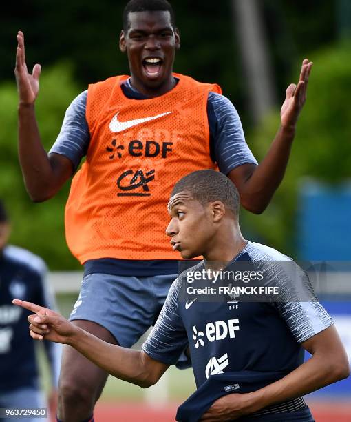 France's midfielder Paul Pogba jokes with France's forward Kylian Mbappe at the end of a training session in Clairefontaine en Yvelines on May 30 as...