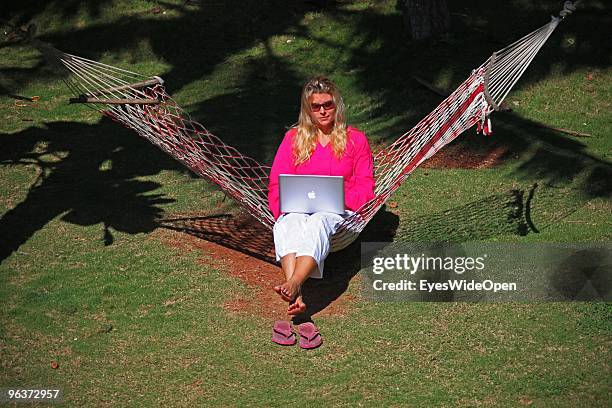 Woman sitting in a hammock and working with a notebook on January 12, 2010 in Varkala near Trivandrum, Kerala, India.