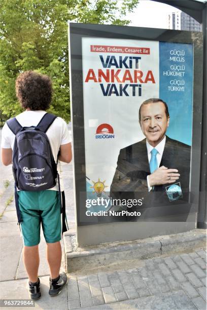 Man stands next to the ruling Justice and Development Party's billboard picturing President Recep Tayyip Erdogan for the early presidential and...