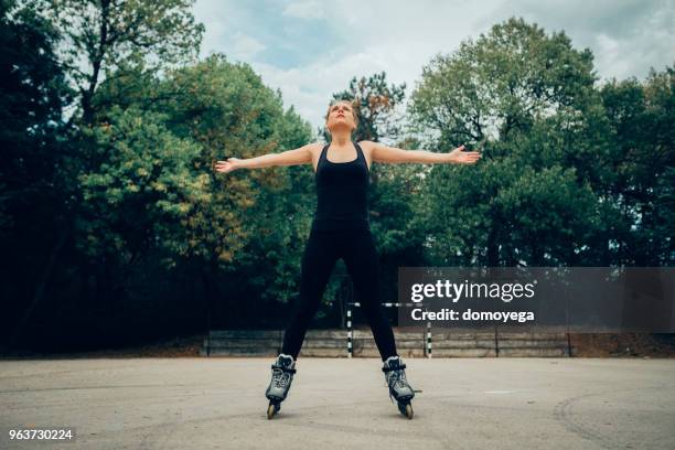 woman inline skates outdoors on a sunny day - inline skate stock pictures, royalty-free photos & images