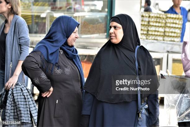 Two women stand outside a bazaar during the Muslim holy fasting month of Ramadan in the historic Ulus district of Ankara, Turkey on May 27, 2018.