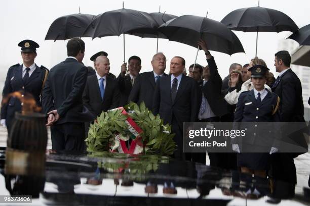 Italian Prime Minister Silvio Berlusconi stands beside Israel's Speaker of the Parliament Reuven Rivlin as he pays his respects at the memorial for...