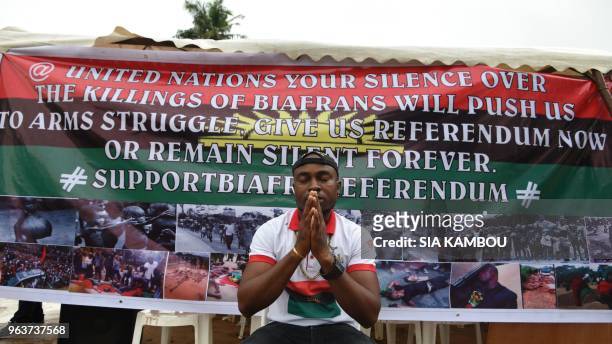 Man prays in front of a banner displayed on May 30, 2018 at the Biafra district in Abidjan during a ceremony commemorating the Biafran War from 1967...
