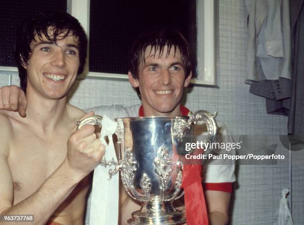 Kenny Dalglish and Alan Hansen of Liverpool celebrate in the dressing room with the trophy after the League Cup Final Replay between Liverpool and...