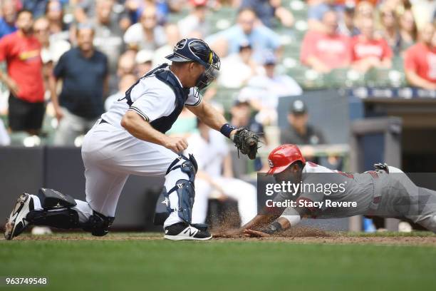 Dexter Fowler of the St. Louis Cardinals beats a tag at home by Erik Kratz of the Milwaukee Brewers during the seventh inning of a game at Miller...