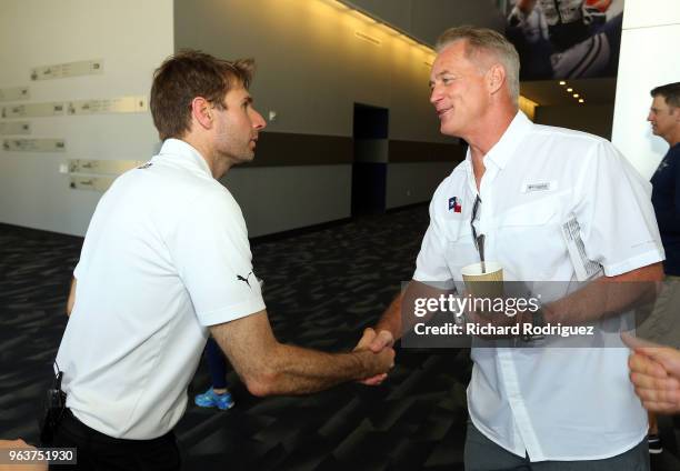 Indianapolis 500 Champion Will Power shakes hands with former Dallas Cowboys fullback Daryl "Moose" Johnston during a tour at The Ford Center at The...