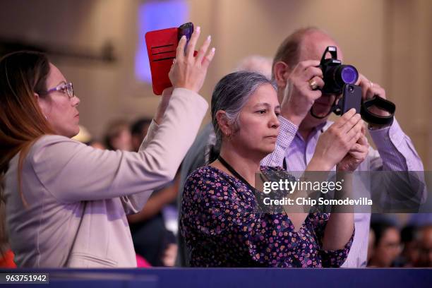 Parents make photographs of their children who are competing in the third round of the 91st Scripps National Spelling Bee at the Gaylord National...