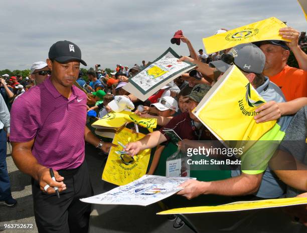 Tiger Woods signs autographs for fans after the Pro-Am round to the Memorial Tournament presented by Nationwide at Muirfield Village Golf Club on May...