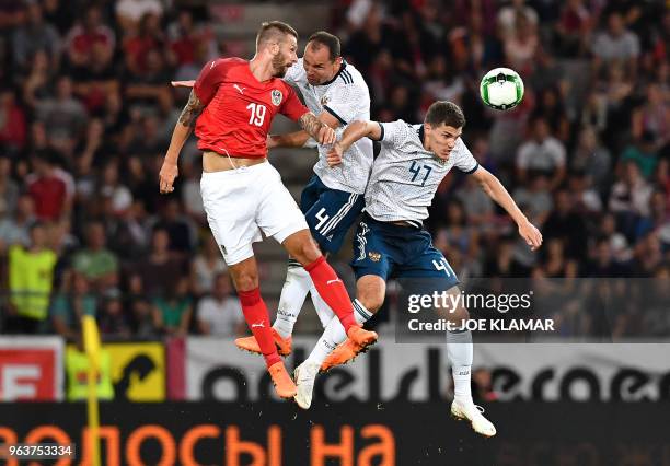 Austria's Guido Burgstaller vie for a ball with Russia's Sergei Ignashevich and Roman Zobnin during their international friendly football match...