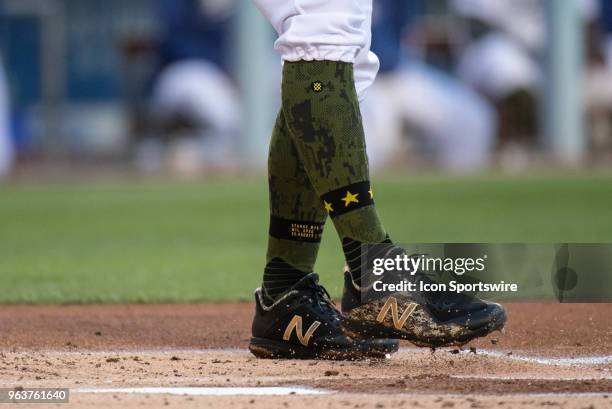 Los Angeles Dodgers' Chris Taylor , wearing socks for Memorial Day weekend, swipes the batters box with his cleats during a Major League Baseball...