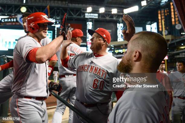 Scott Schebler of the Cincinnati Reds is congratulated in the dugout after hitting a two run home run in the sixth inning of the MLB game against the...