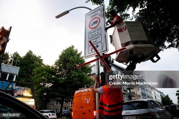 Workers removes a marker to validate a sign that bans access for older-model diesel cars on a street on May 30, 2018 in Hamburg, Germany. The city is...