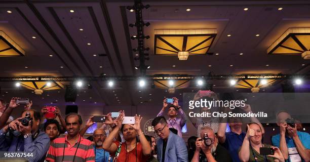 Proud parents make photographs of the 41 finalists at the end of the third round of the 91st Scripps National Spelling Bee at the Gaylord National...