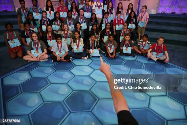 Photographer Mark Bowen directs the 41 finalists for an image at the conclusion of the third day of the 91st Scripps National Spelling Bee at the...