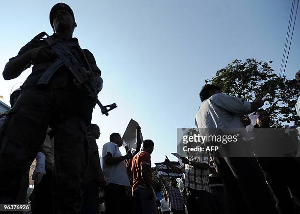 Sri Lankan special forces commando stands guard as pro-opposition youth activists demonstrate in favour of former army chief and defeated...