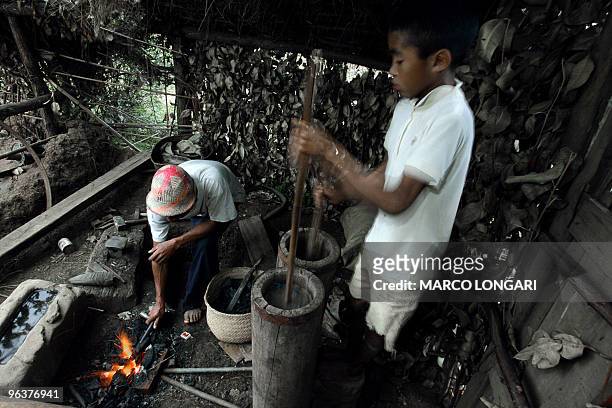 Manisa Ranarijaona helps his father Solomanga Ranarijaona with his acttivity as a blacksmith 04 December 2005 in their little workshop in the...