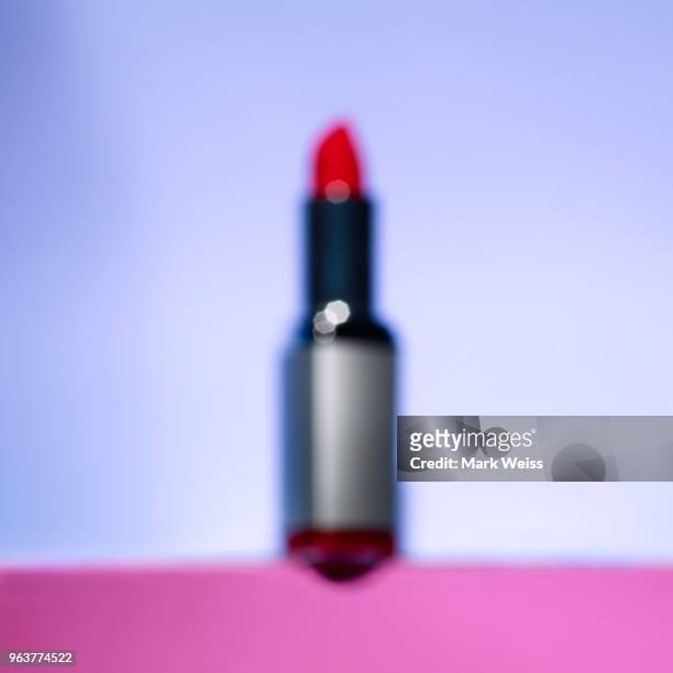 out of focus red lipstick in silver tube on pink and purple horizon background - silver lipstick stock pictures, royalty-free photos & images