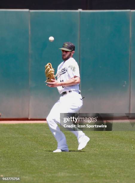 Oakland LF Chad Pinder tries to field a ball that took a bad bounce in the inter-league game between the Arizona Diamondbacks and the Oakland A's...