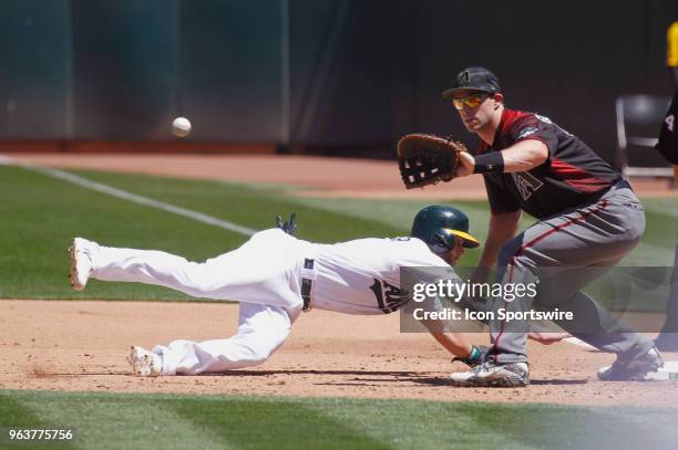 Oakland CF Dustin Fowler dives back into the bag during the inter-league game between the Arizona Diamondbacks and the Oakland A's played on May 27,...