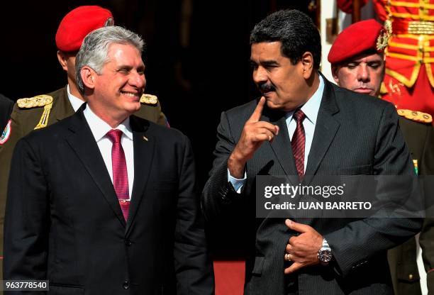 Cuban President Miguel Diaz-Canel and his Venezuelan counterpart Nicolas Maduro chat during a meeting at Miraflores presidential palace in Caracas on...