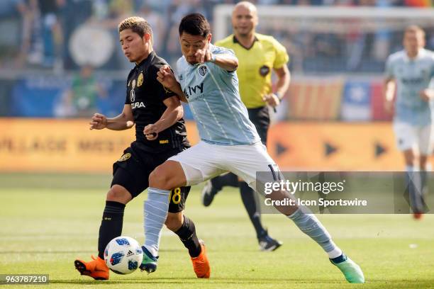 Sporting Kansas City midfielder Roger Espinoza shields off Columbus Crew midfielder Cristian Martinez during the MLS regular season match between...