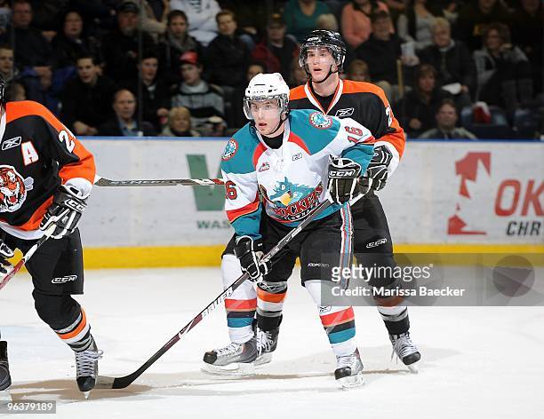 Spencer Main of the Kelowna Rockets is checked by Dylan Busenius of the Medicine Hat Tigers at Prospera Place on January 30, 2010 in Kelowna, Canada.