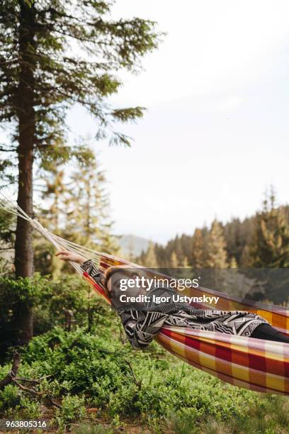 young woman resting in hammock - frühjahrsmüdigkeit frau stock-fotos und bilder