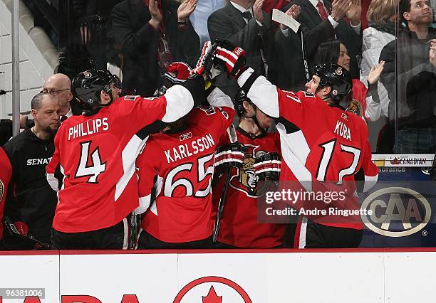 Chris Phillips, Erik Karlsson and Filip Kuba of the Ottawa Senators celebrate a goal against the New Jersey Devils at the bench at Scotiabank Place...