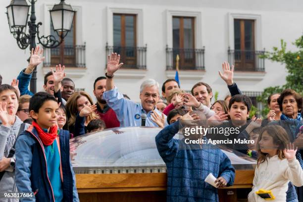 President of Chile, Sebastián Piñera; greets the press with a group of visitors as he shows the Palacio de la Moneda scale reproduction during the...