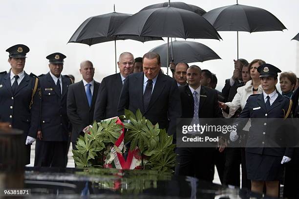 Italian Prime Minister Silvio Berlusconi accompanied by Israel's Speaker of the Parliament Reuven Rivlin pays his respects at the memorial for fallen...