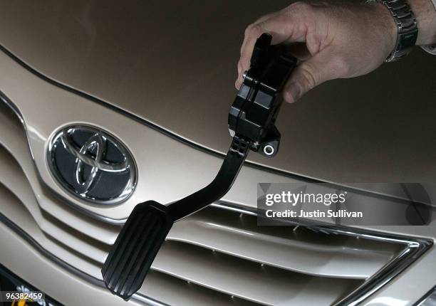 City Toyota service manager Jim Lasseter holds a recalled accelerator pedal next to a brand new Toyota Camry that is scheduled to be fixed February...