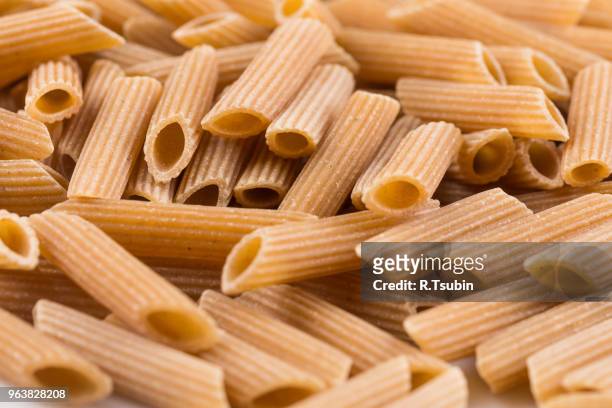 wholemeal pasta penne as close-up shot for background - vollkorn stock pictures, royalty-free photos & images