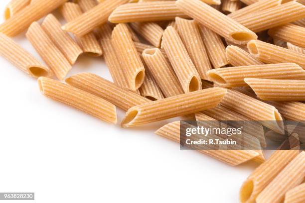 wholemeal pasta penne as close-up shot isolated on white background - vollkorn stock pictures, royalty-free photos & images