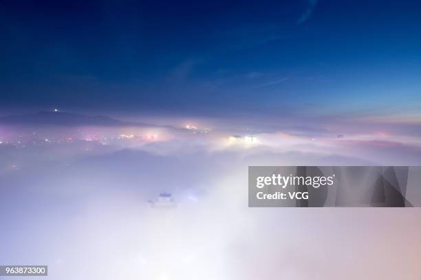 Advection fog surrounds office buildings and residential buildings on May 29, 2018 in Yantai, China.