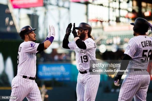Nolan Arenado of the Colorado Rockies celebrates his three run home run with Charlie Blackmon and Noel Cuevas during the first inning against the San...