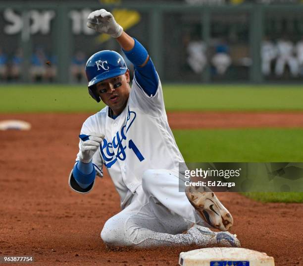 Ryan Goins of the Kansas City Royals slides into third for a two-run triple in the second inning against the Minnesota Twins at Kauffman Stadium on...